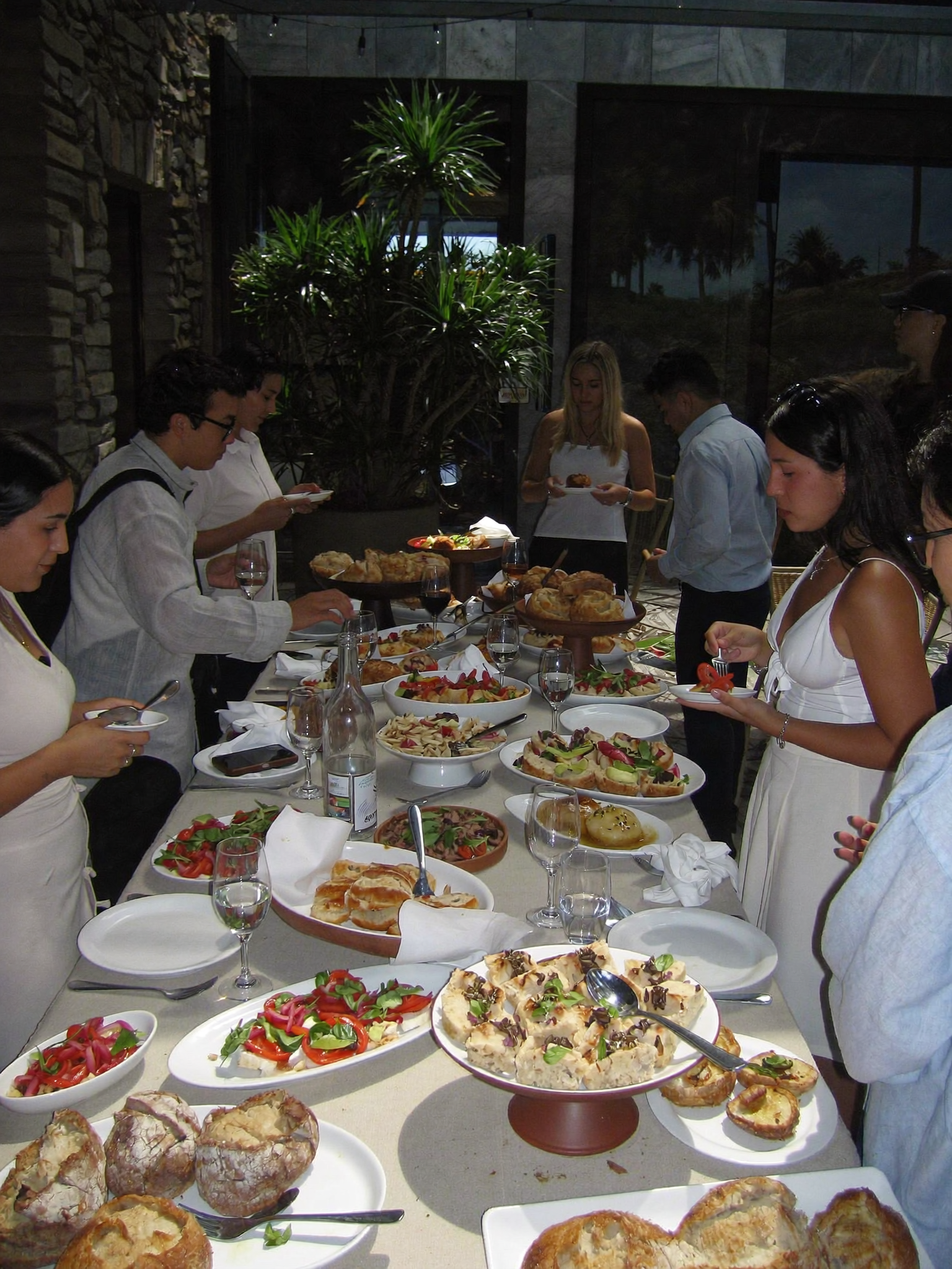 Invitados disfrutando de una mesa de catering durante un evento social.
